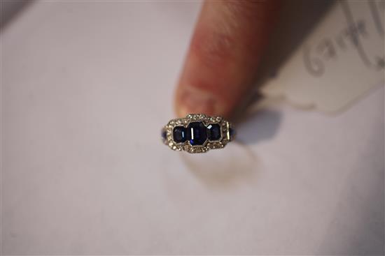 A white gold three stone sapphire and diamond cluster ring, size M.